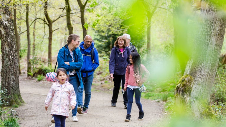 A family group exploring the woodland trails at Quarry Bank Mill, Cheshire